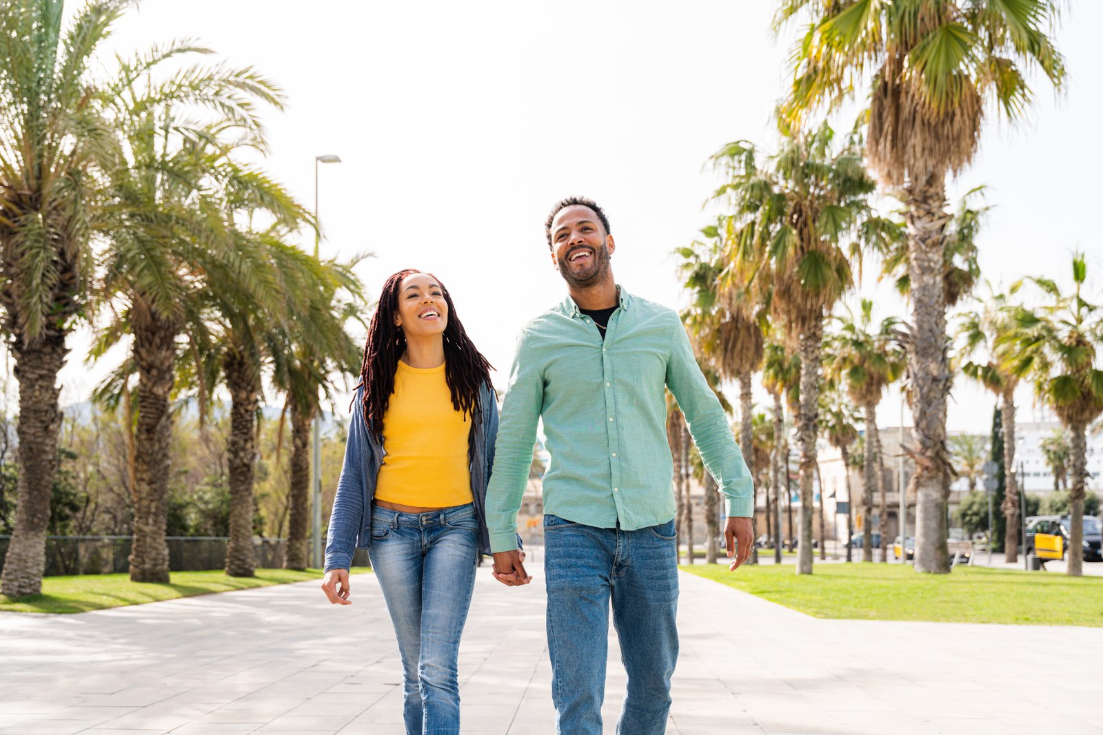 Couple walking hand in hand among palm trees in Florida, symbolizing family protection and life insurance guidance.